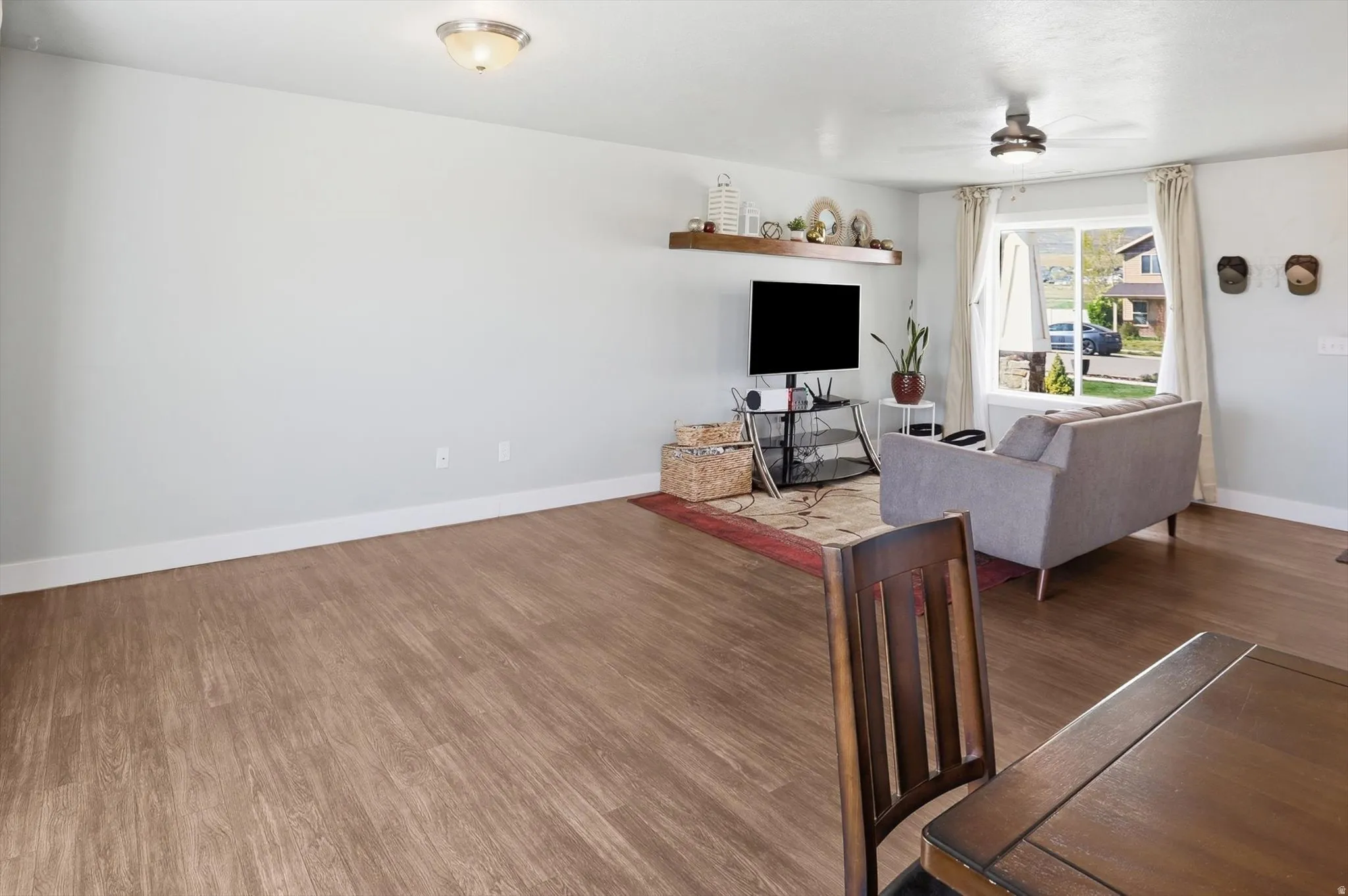 Living area featuring wood finished floors and a ceiling fan