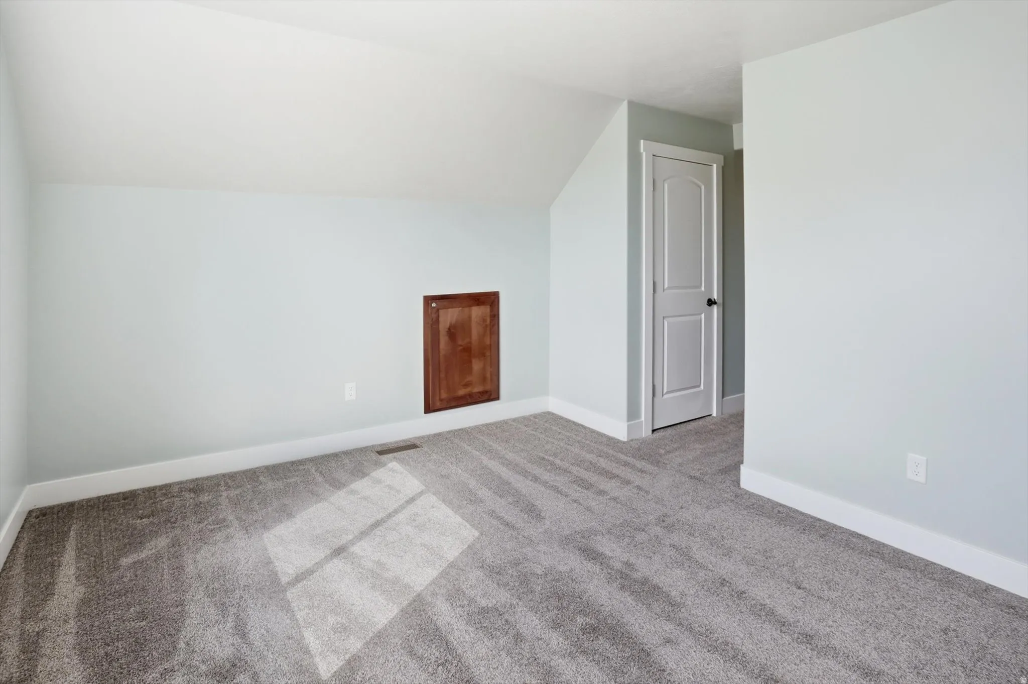 Bonus room featuring vaulted ceiling and light carpet
