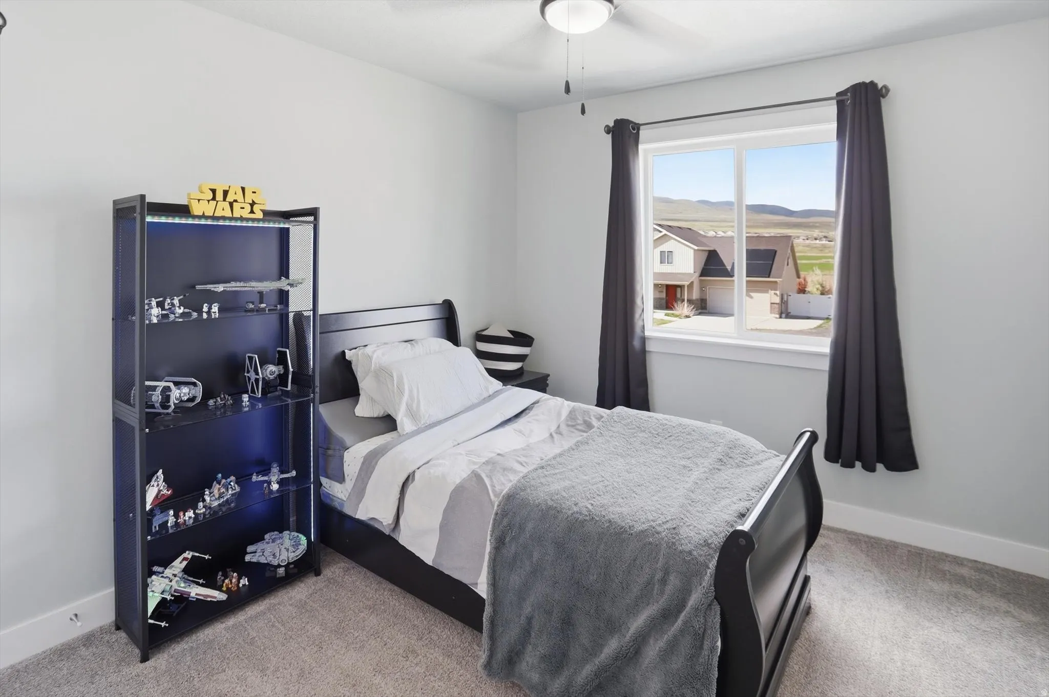 Bedroom with light carpet, a mountain view, and ceiling fan