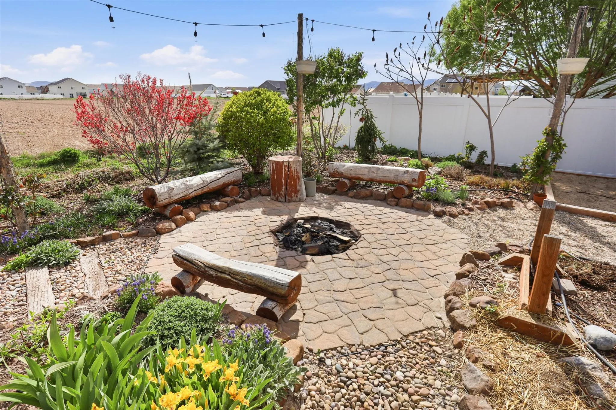 Fenced backyard featuring a patio area, an outdoor fire pit, and a residential view