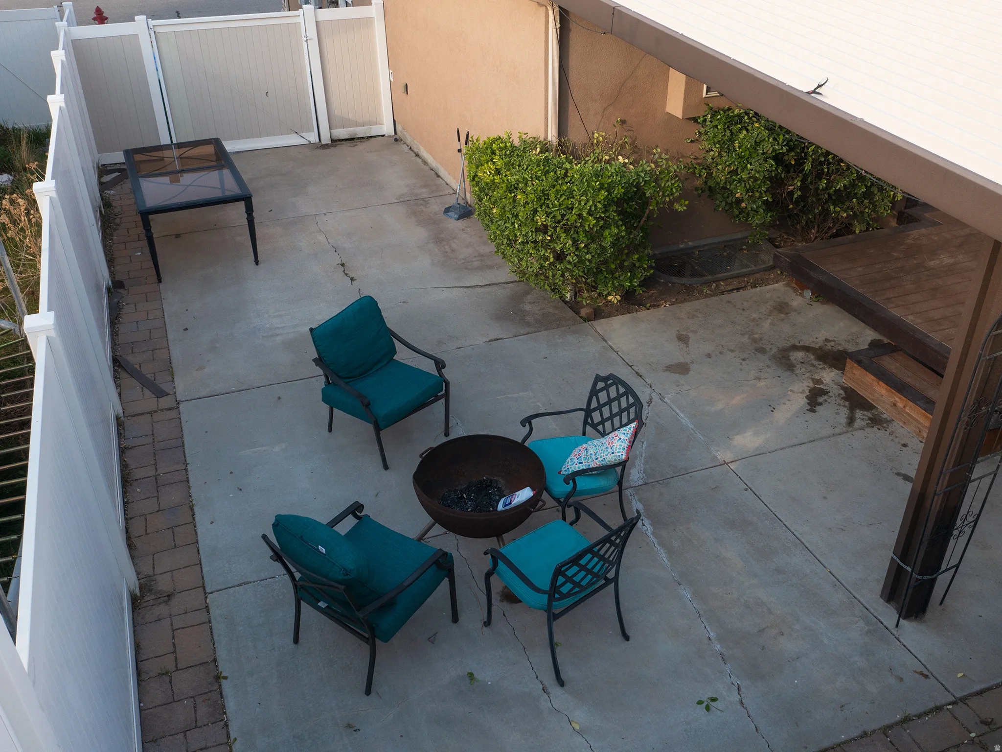 View of patio featuring an outdoor fire pit and a gate
