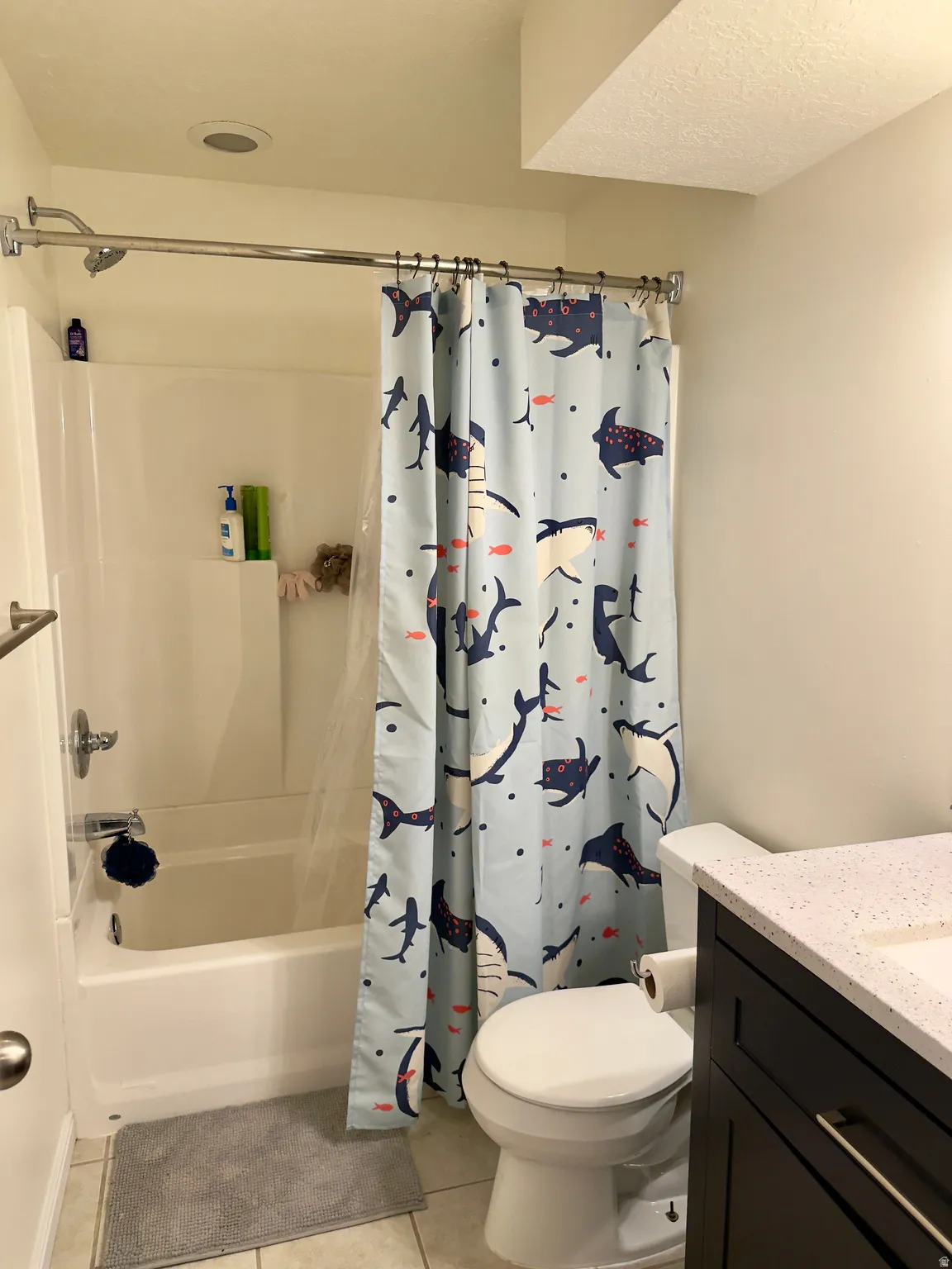Bathroom with vanity, light tile patterned floors, and shower / bath combination with curtain
