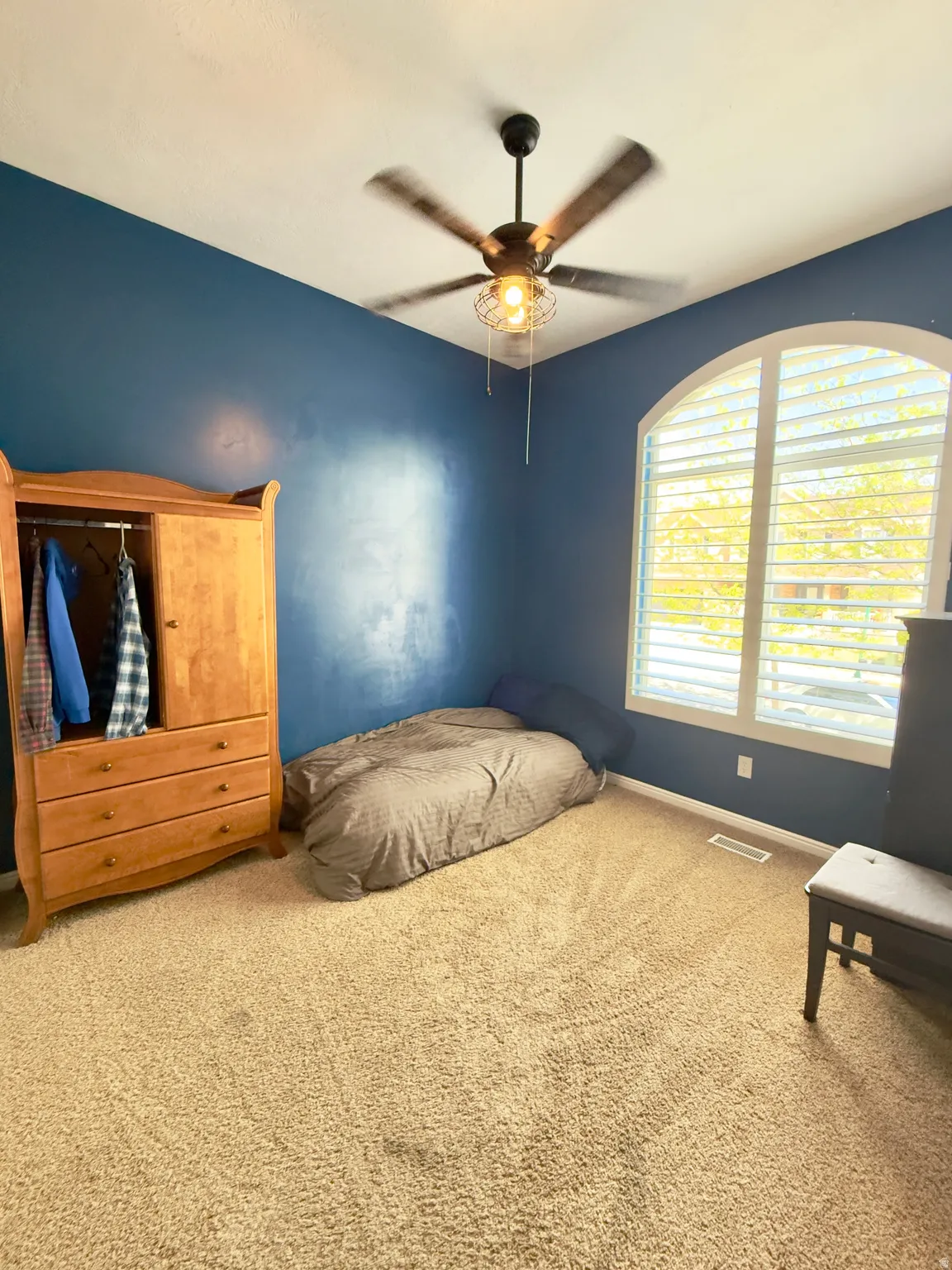 Carpeted bedroom with baseboards and a ceiling fan