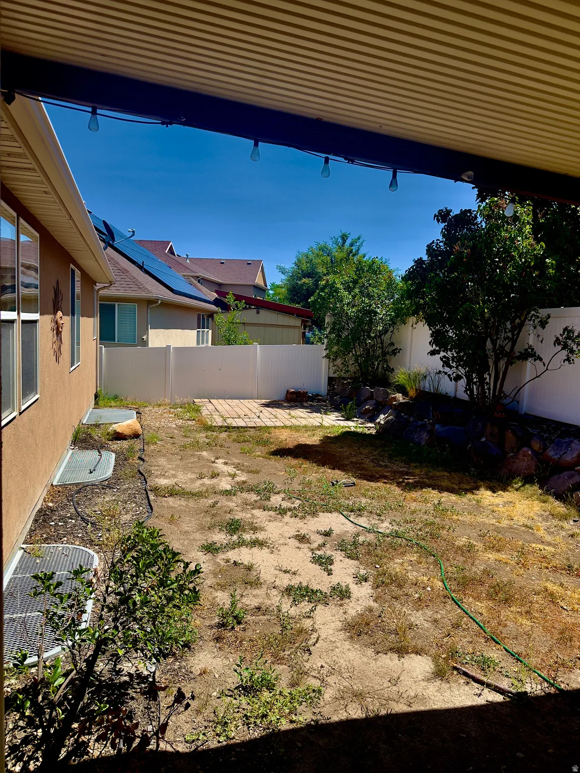 Covered patio area opening to a private backyard