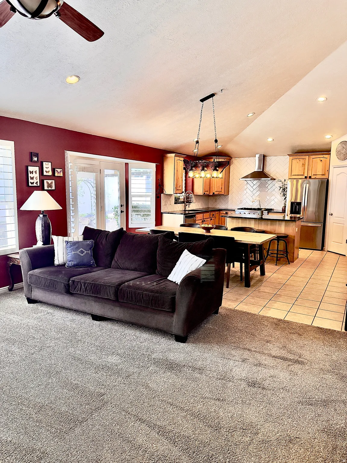 Living area featuring light carpet, recessed lighting, ceiling fan, and a textured ceiling