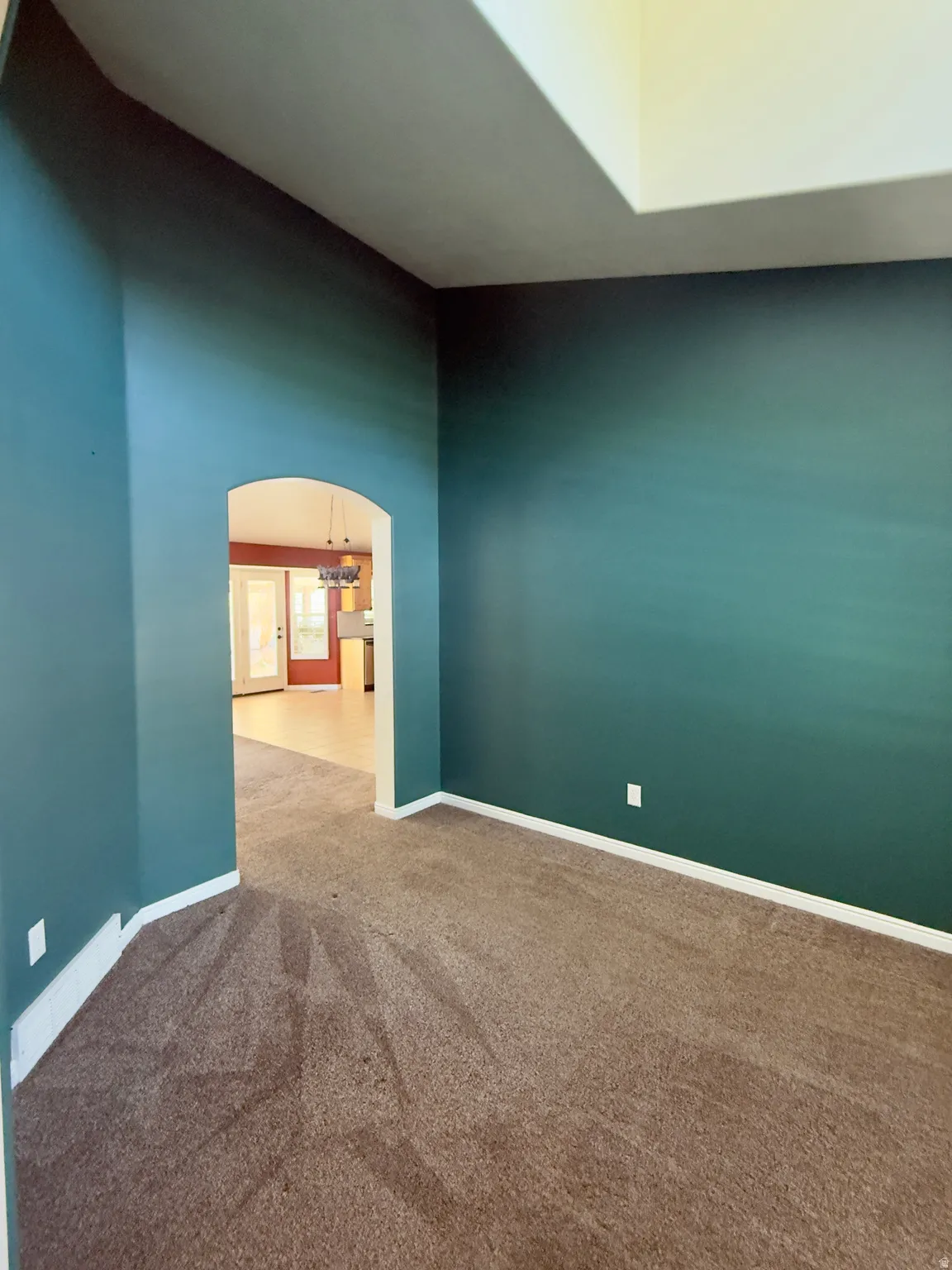 Interior space featuring vibrant teal walls and brown carpeting