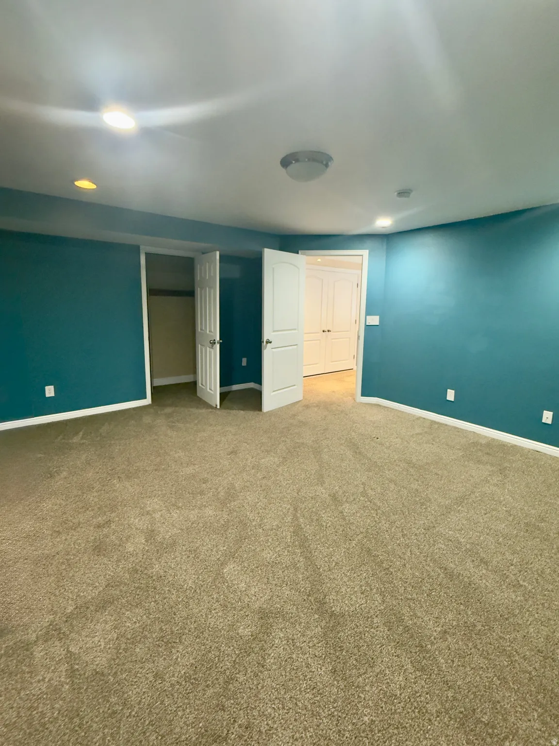 Spacious room featuring carpeting, recessed lighting, and a closet with a bi-fold door