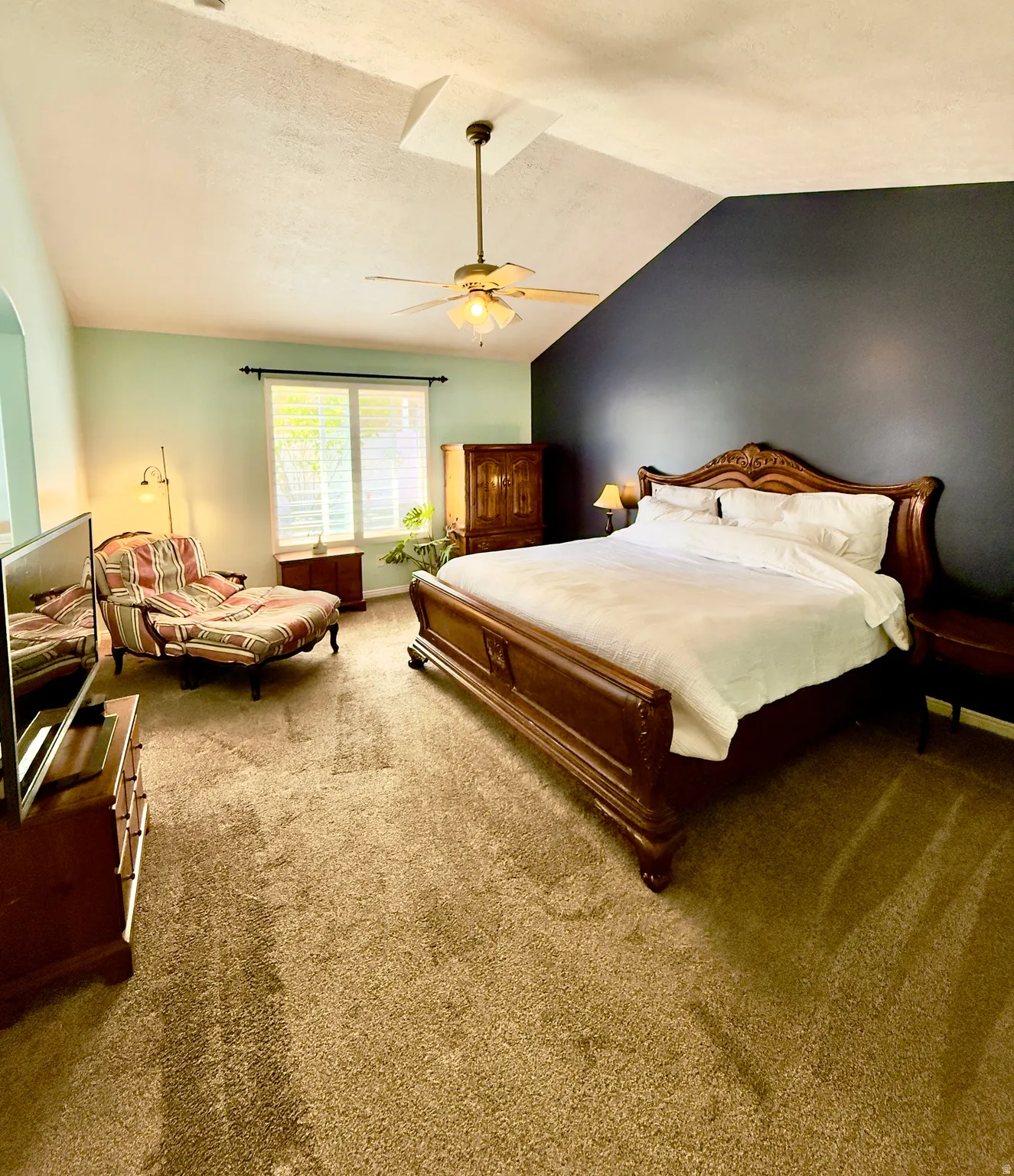 Bedroom with carpet, vaulted ceiling, and ceiling fan