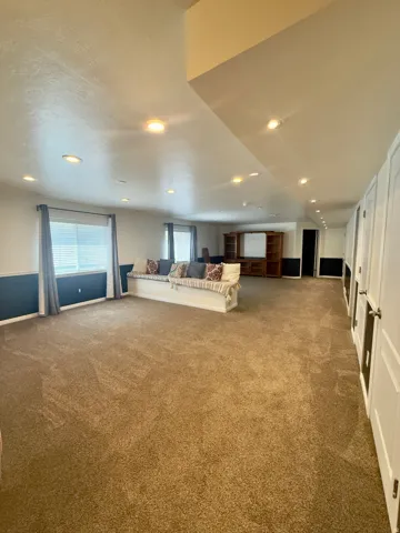 Spacious room with recessed lighting and neutral-toned carpeting