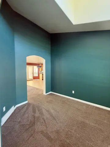 Interior space featuring vibrant teal walls and brown carpeting