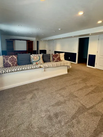Spacious room featuring broadloom carpeting and a built-in bench seating area