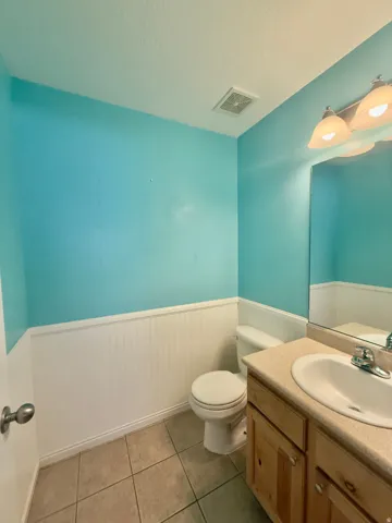 Bathroom featuring a single vanity with a light-toned countertop, an integrated sink, and a chrome faucet