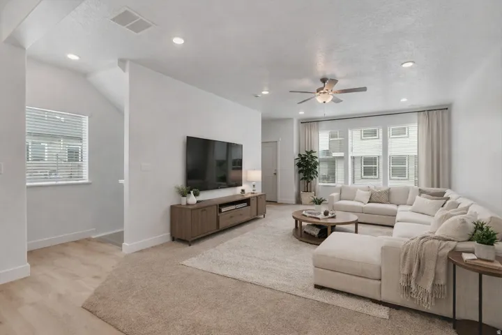 Living area with ceiling fan, a textured ceiling, and recessed lighting