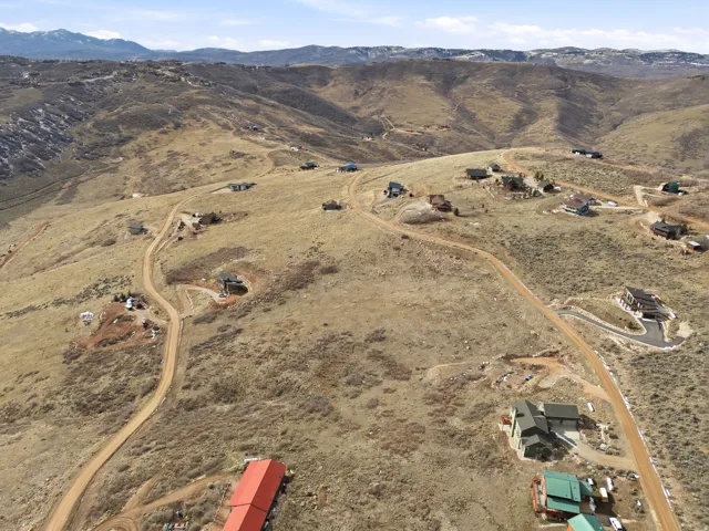 Aerial view of property and surrounding area with a mountainous background and rural landscape