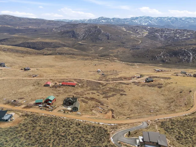 Aerial view of property and surrounding area featuring a mountain backdrop and rural landscape
