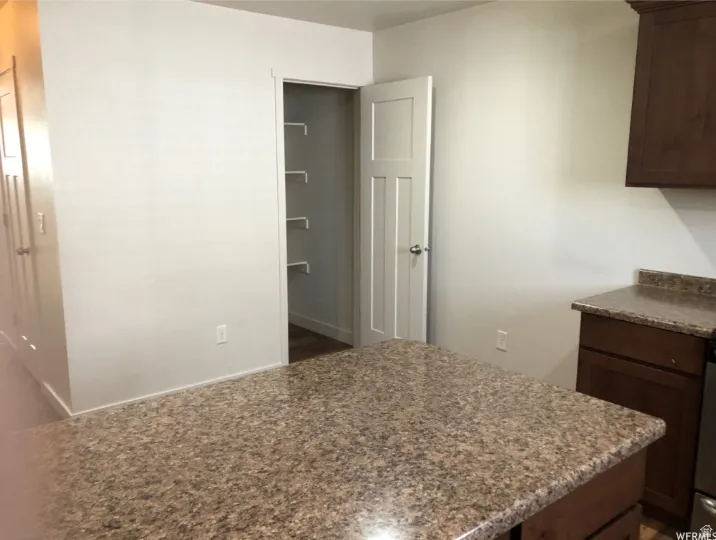 Kitchen featuring dark wood finish cabinetry and baseboards