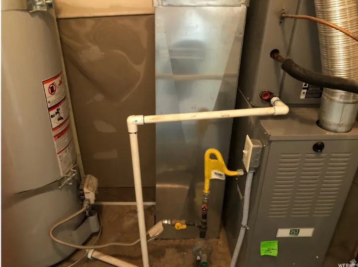 Utility room featuring water heater and heating unit
