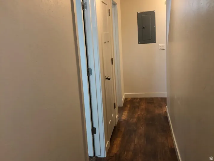 Hall featuring electric panel and dark wood finished floors