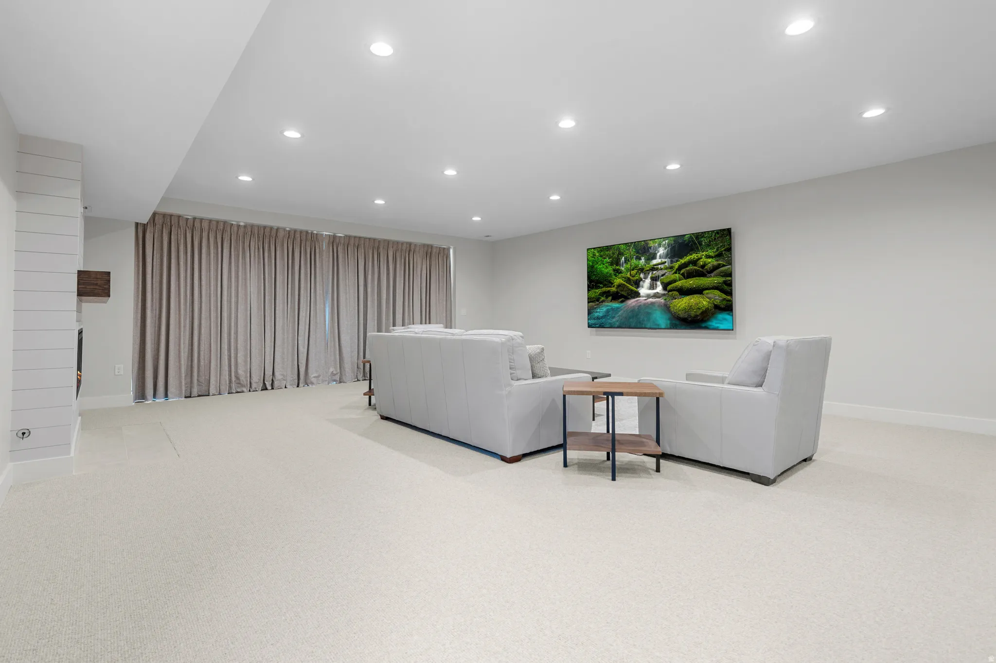Living area featuring light colored carpet and recessed lighting