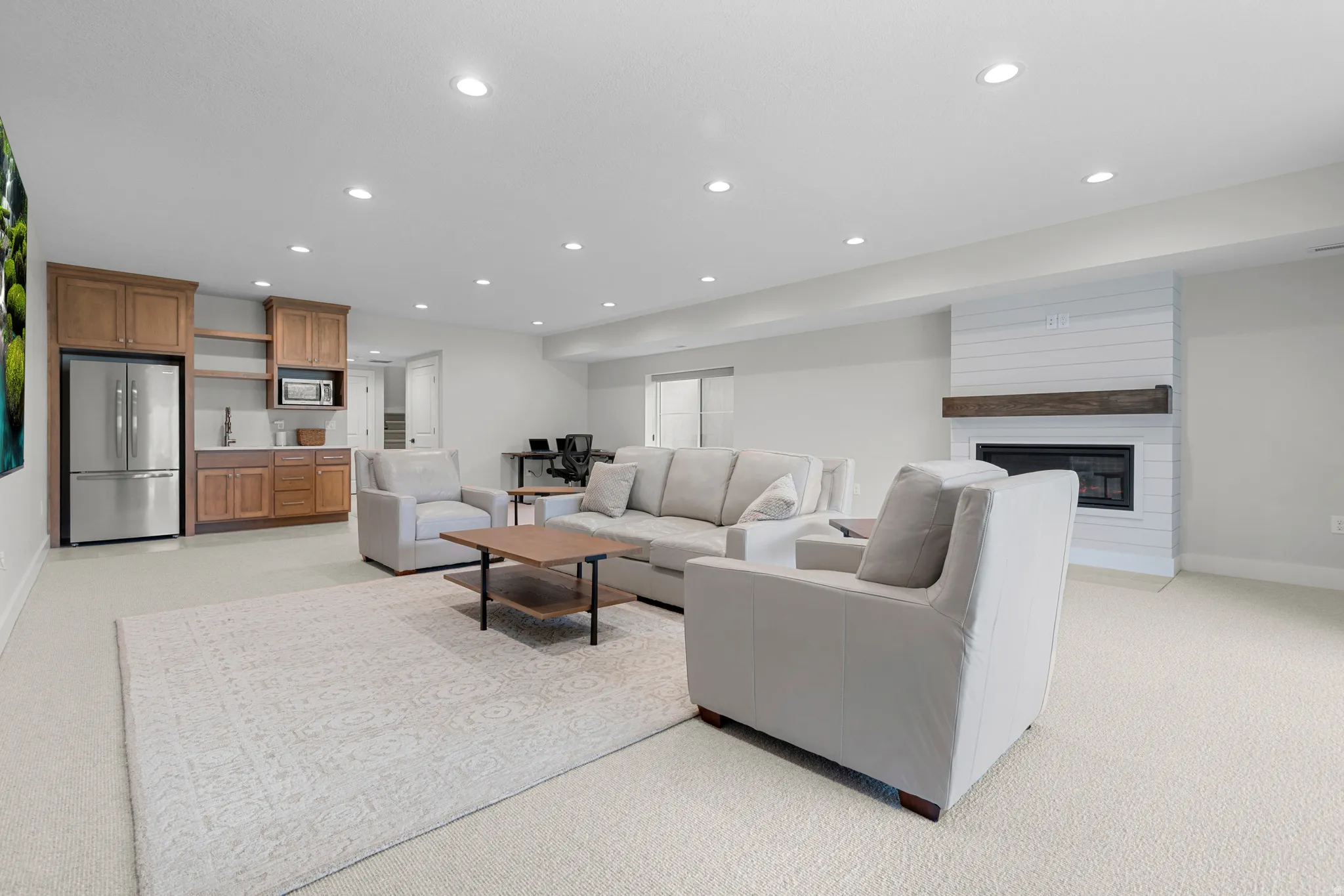 Living room featuring recessed lighting, light colored carpet, and a fireplace