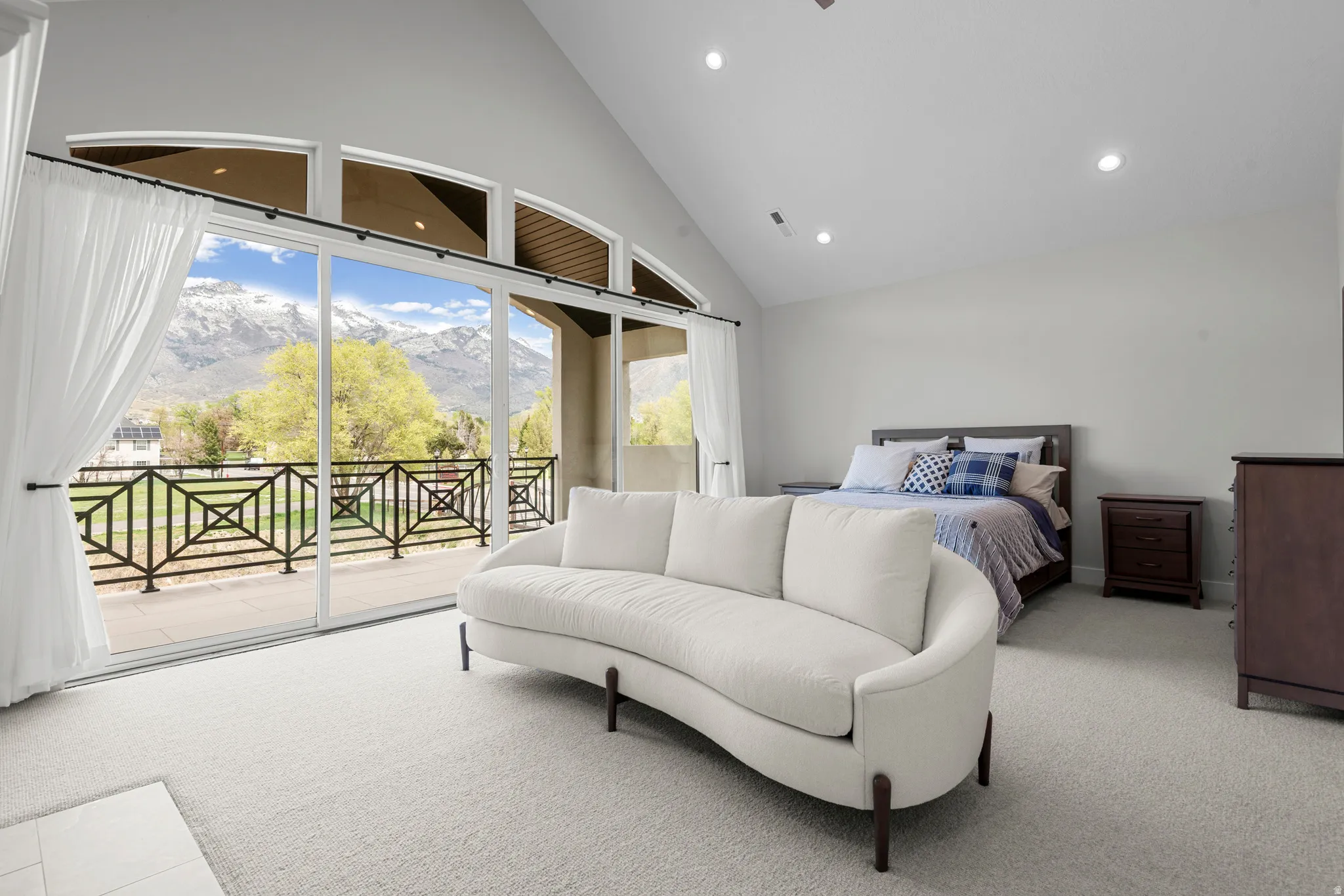 Bedroom featuring a mountain view, access to outside, multiple windows, light carpet, and vaulted ceiling