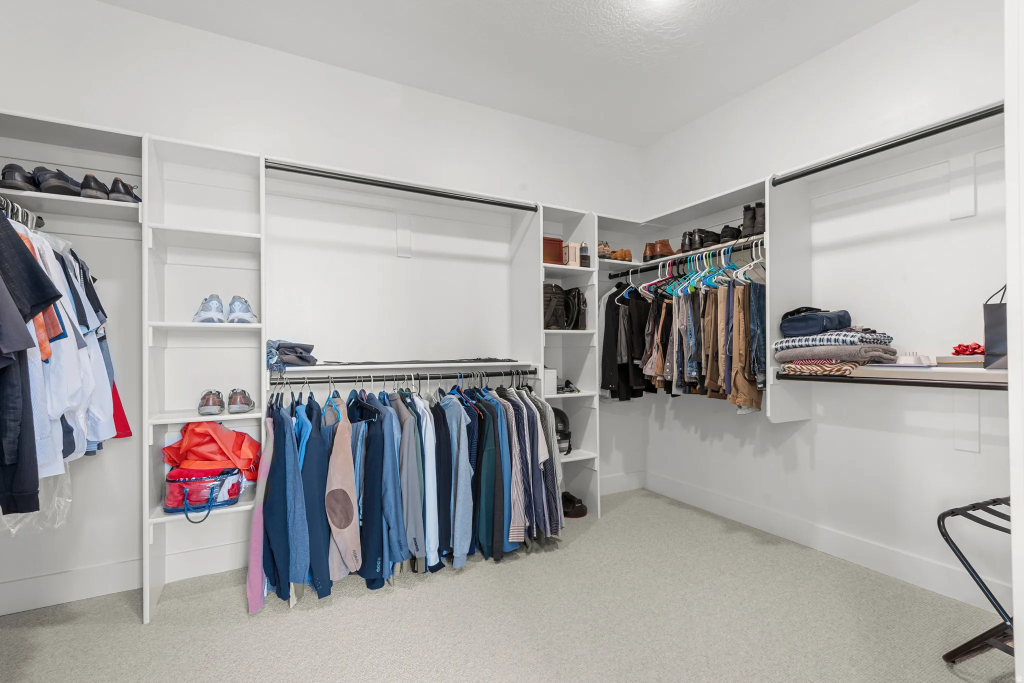 Walk in closet featuring light colored carpet