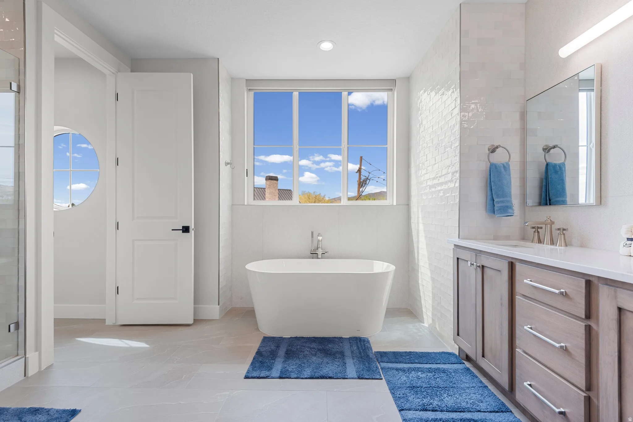 Full bathroom featuring a freestanding bath, vanity, and a shower stall