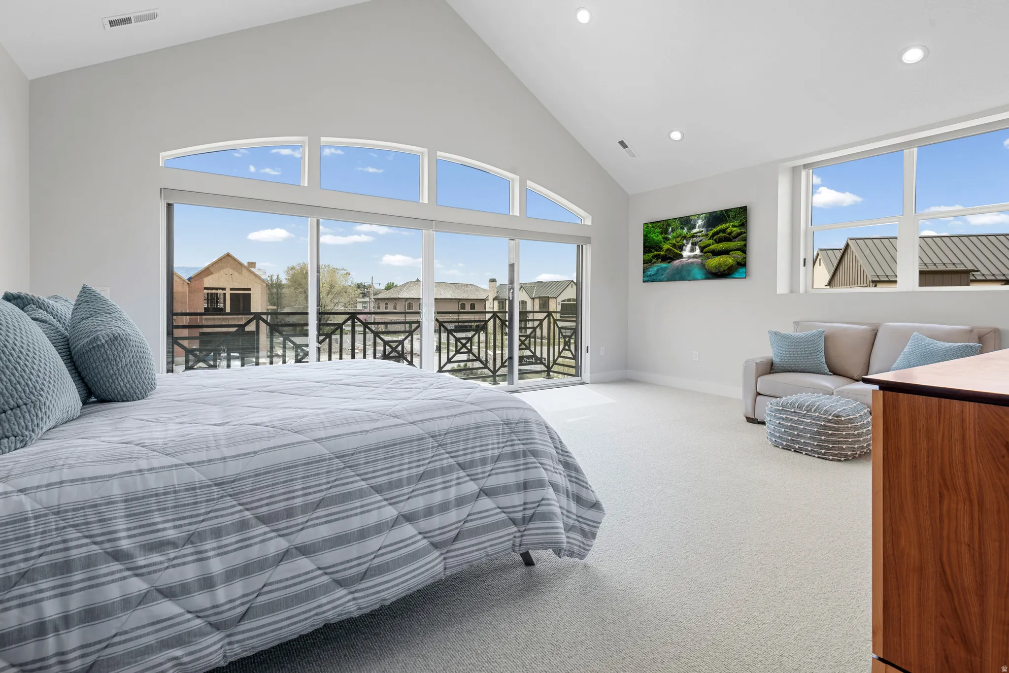Bedroom featuring a high ceiling, light carpet, access to exterior, and recessed lighting