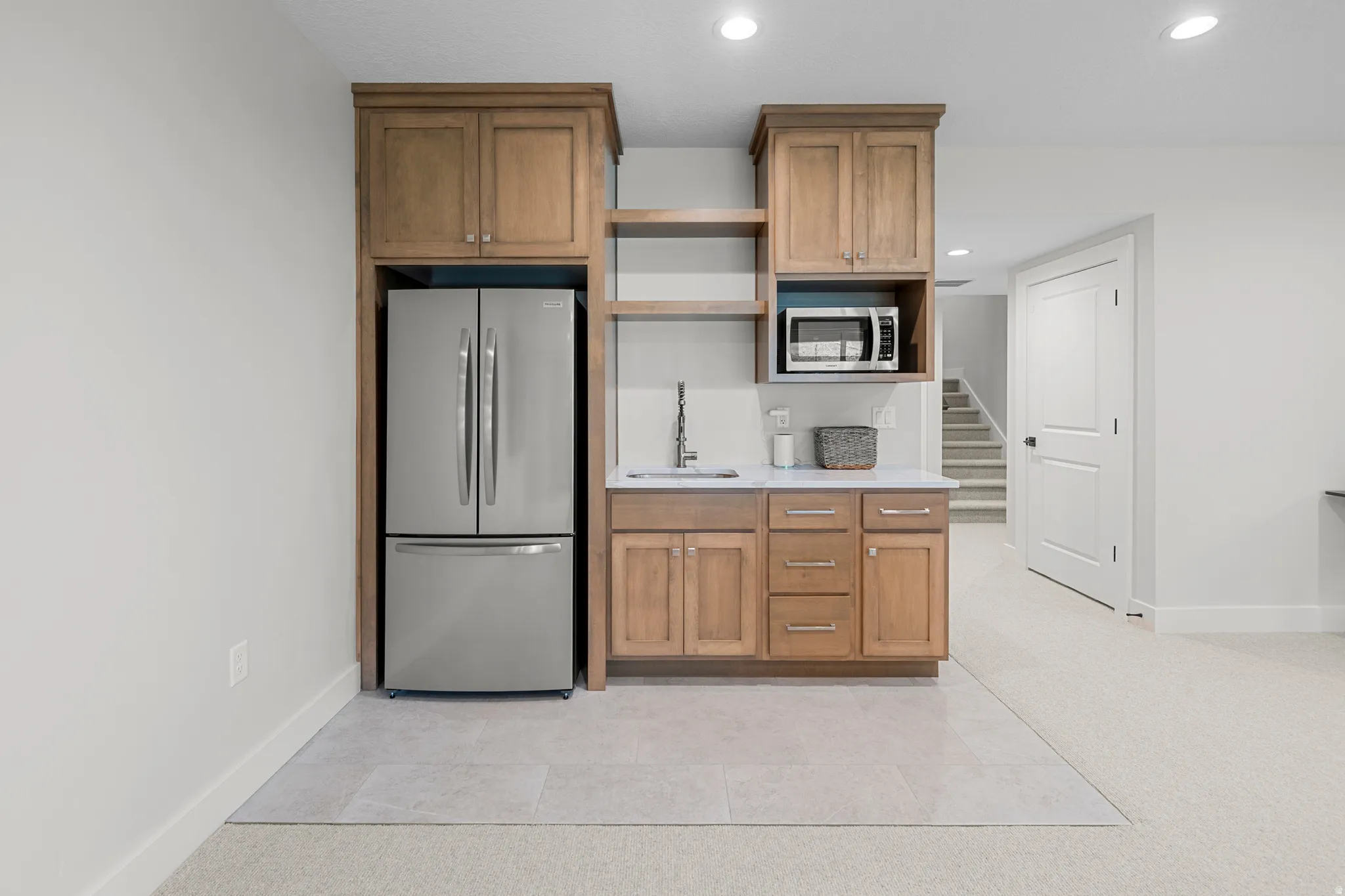 Kitchen featuring stainless steel appliances, wood finish cabinets, open shelves, recessed lighting, and light tile patterned floors
