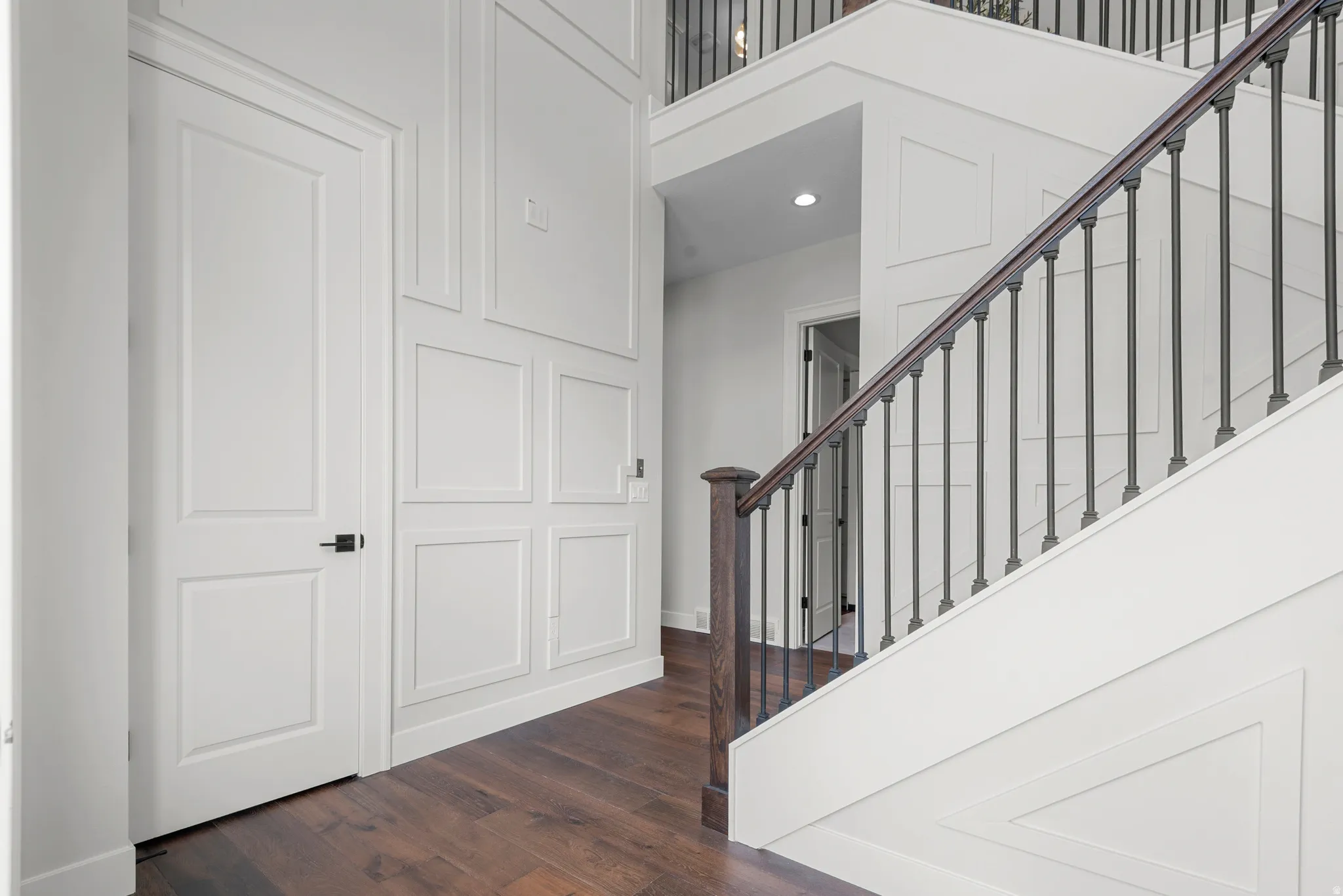 Staircase with wood finished floors and recessed lighting