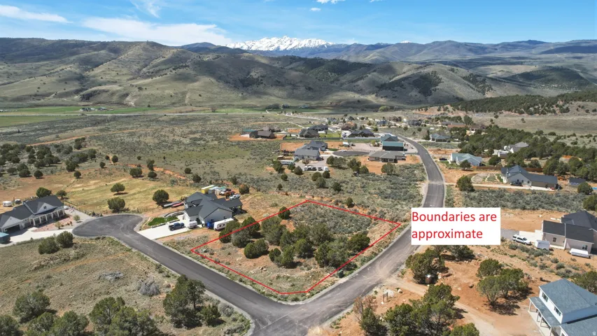 Aerial perspective of suburban area featuring property boundaries highlighted (boundaries are approximate) and a mountainous background
