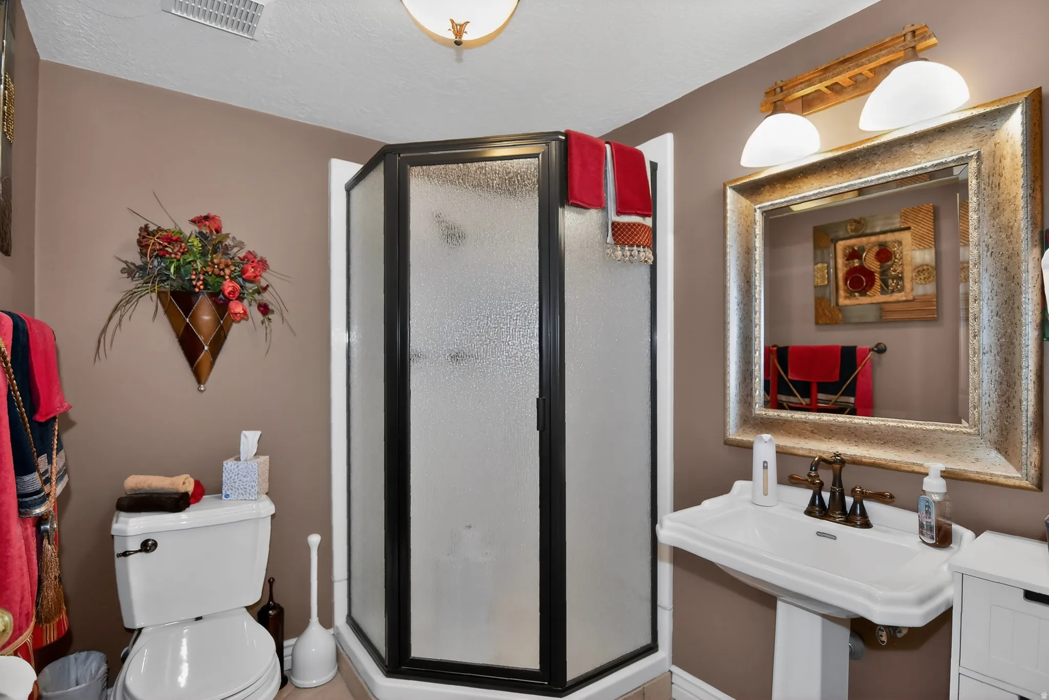 Bathroom featuring a shower stall and a textured ceiling