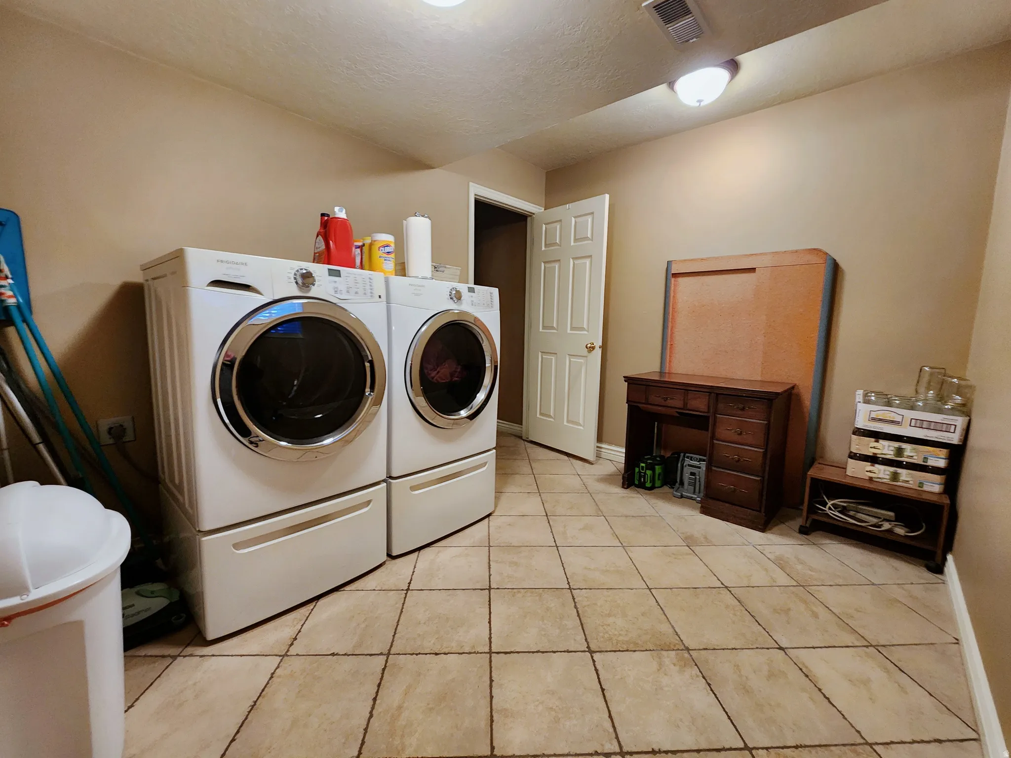 Laundry room featuring washer and dryer and light tile patterned flooring