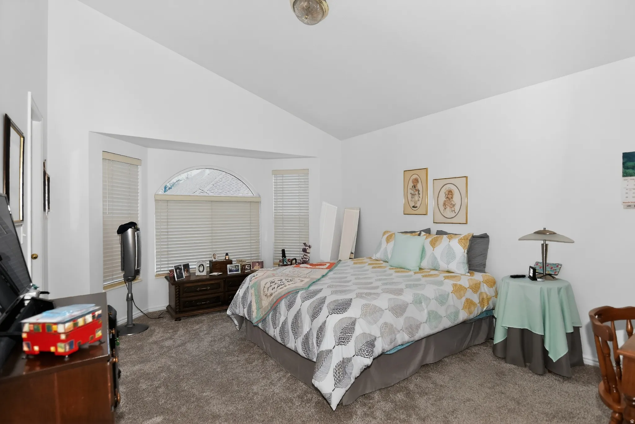 Bedroom featuring lofted ceiling and dark carpet