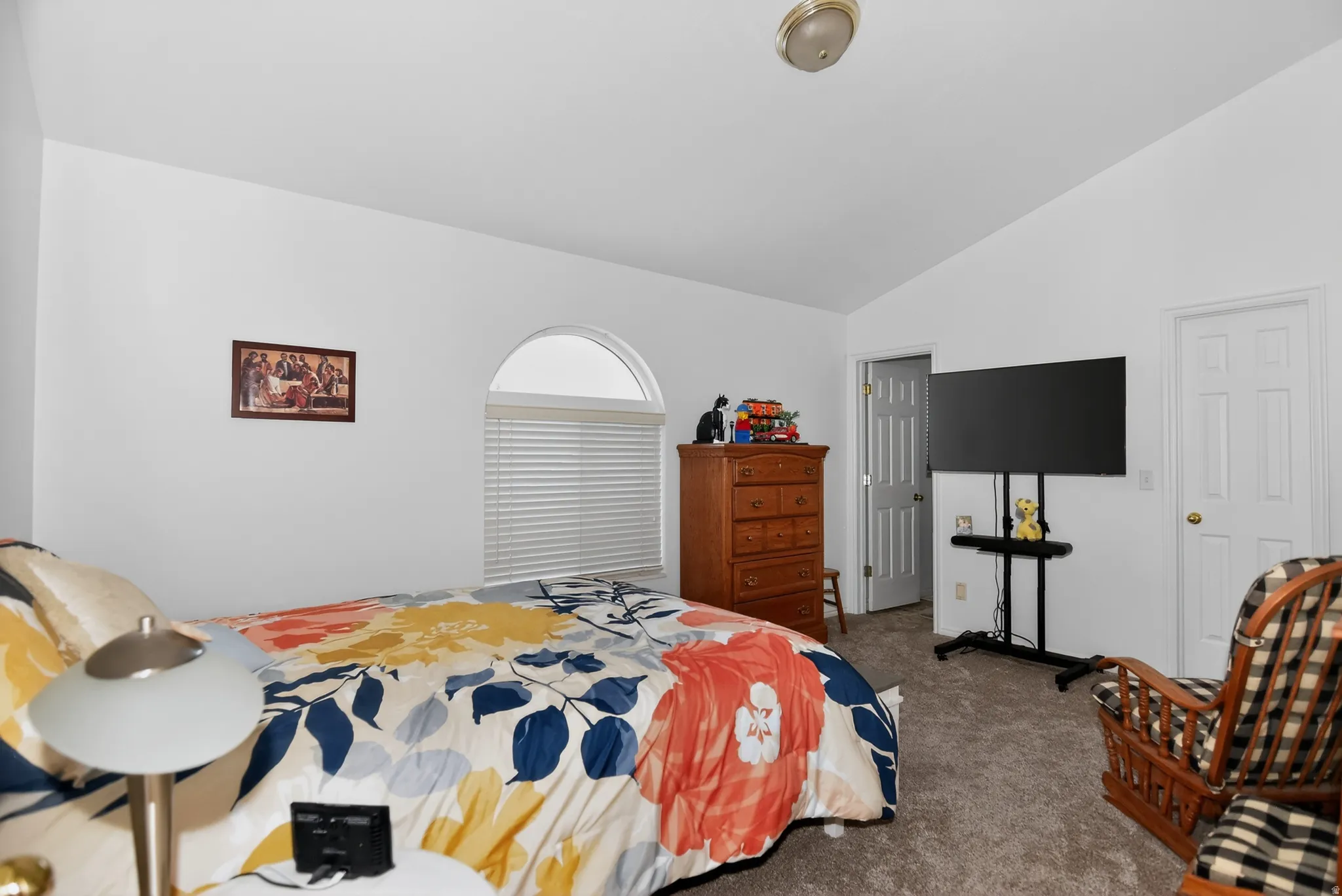 Bedroom featuring lofted ceiling and carpet