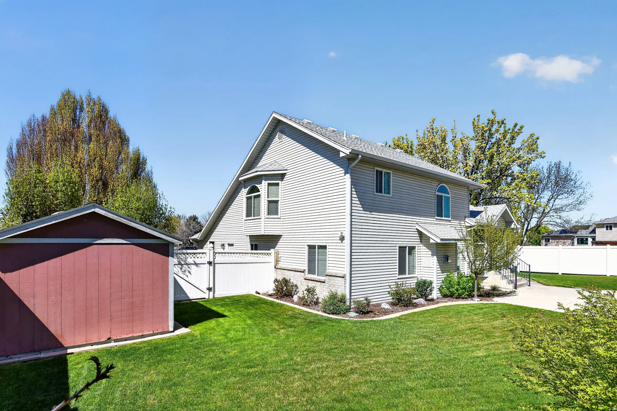 View of side of property featuring a fenced backyard, a shed, and a gate