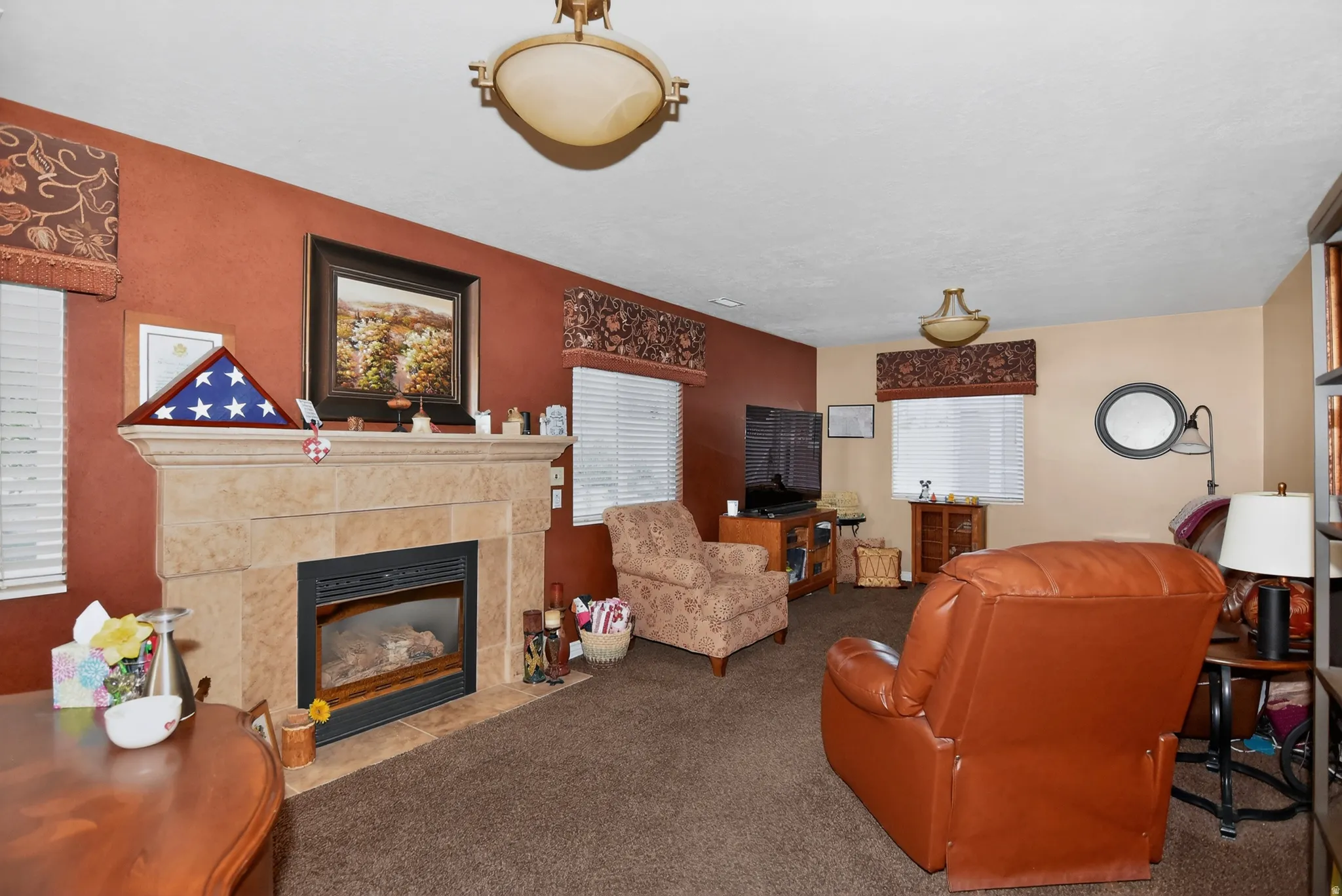 Living room featuring a tiled fireplace and carpet flooring