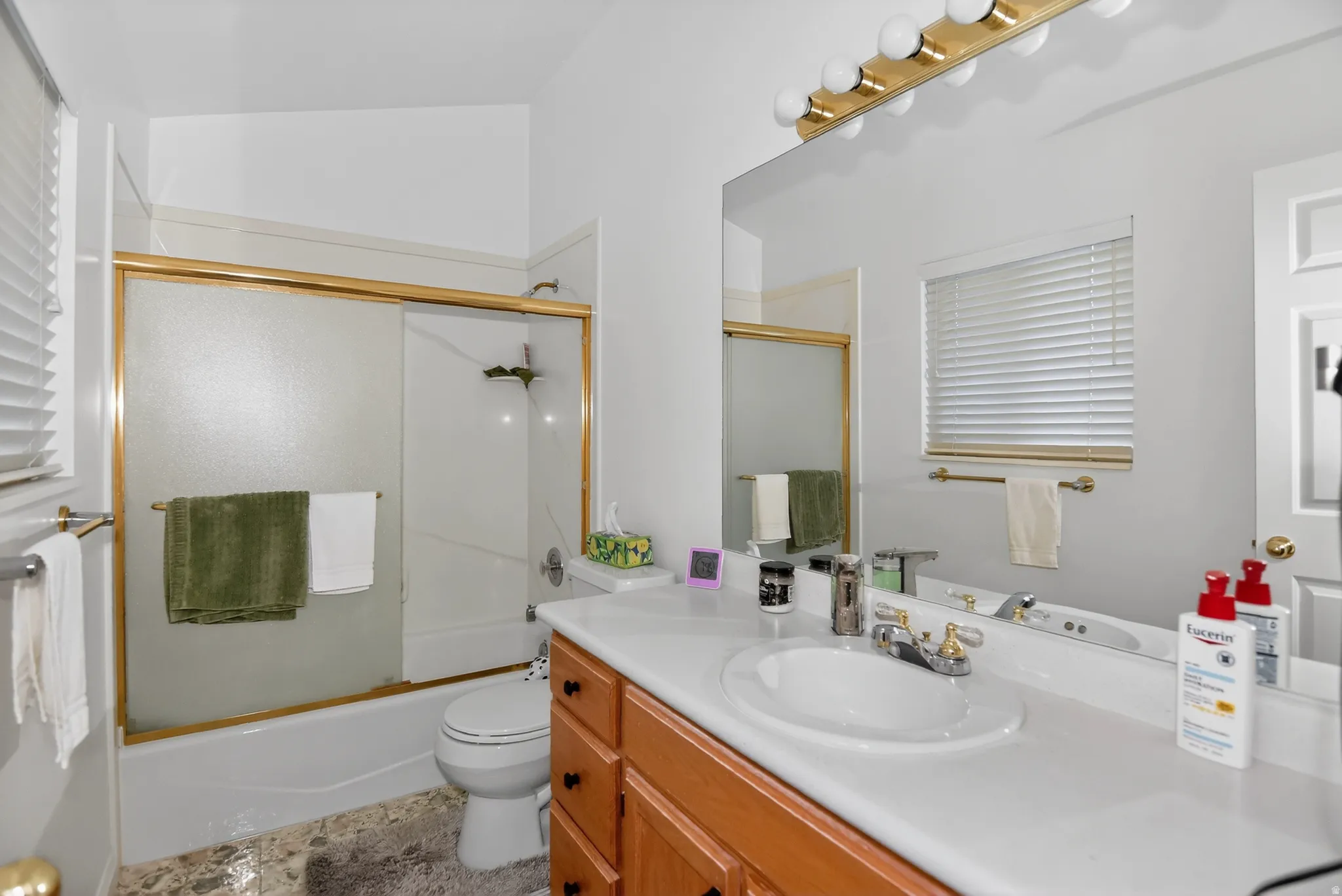 Bathroom featuring vanity and enclosed tub / shower combo