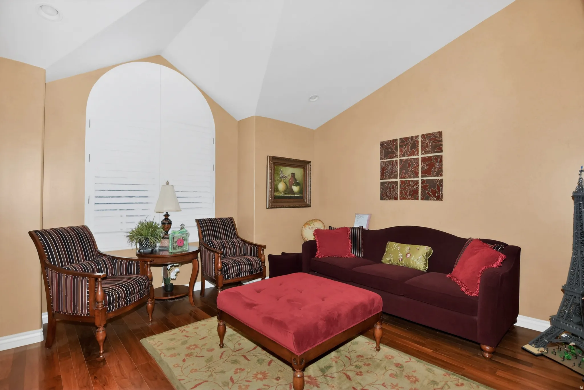 Living area with vaulted ceiling and hardwood / wood-style floors