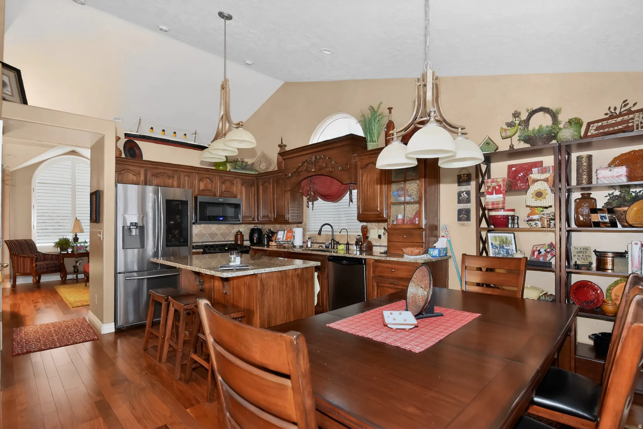 Dining room with lofted ceiling and dark wood-style floors