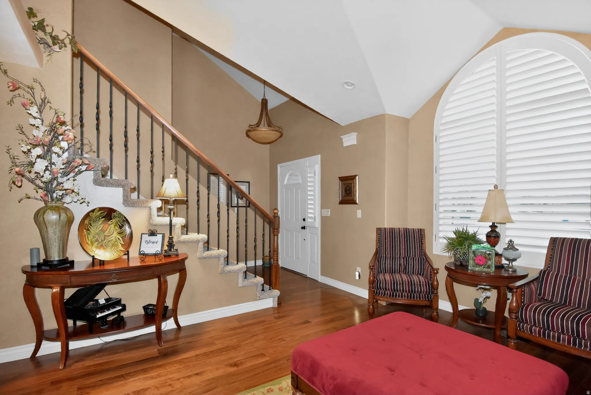 Foyer entrance with wood finished floors and vaulted ceiling