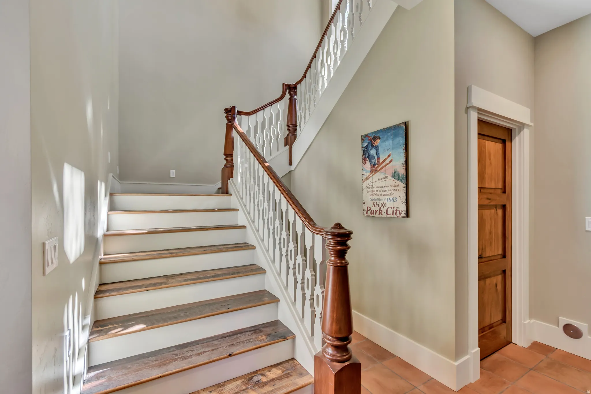 Stairway featuring tile patterned floors and a high ceiling