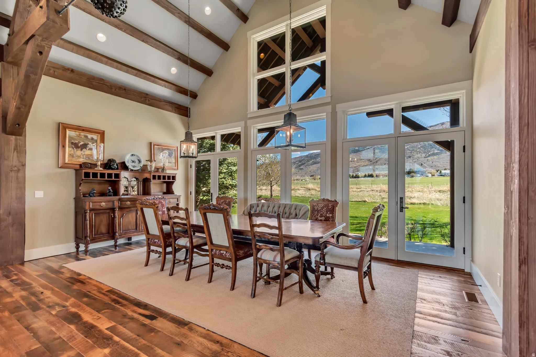 Dining area with a mountain view, wood finished floors, vaulted ceiling, recessed lighting, and french doors