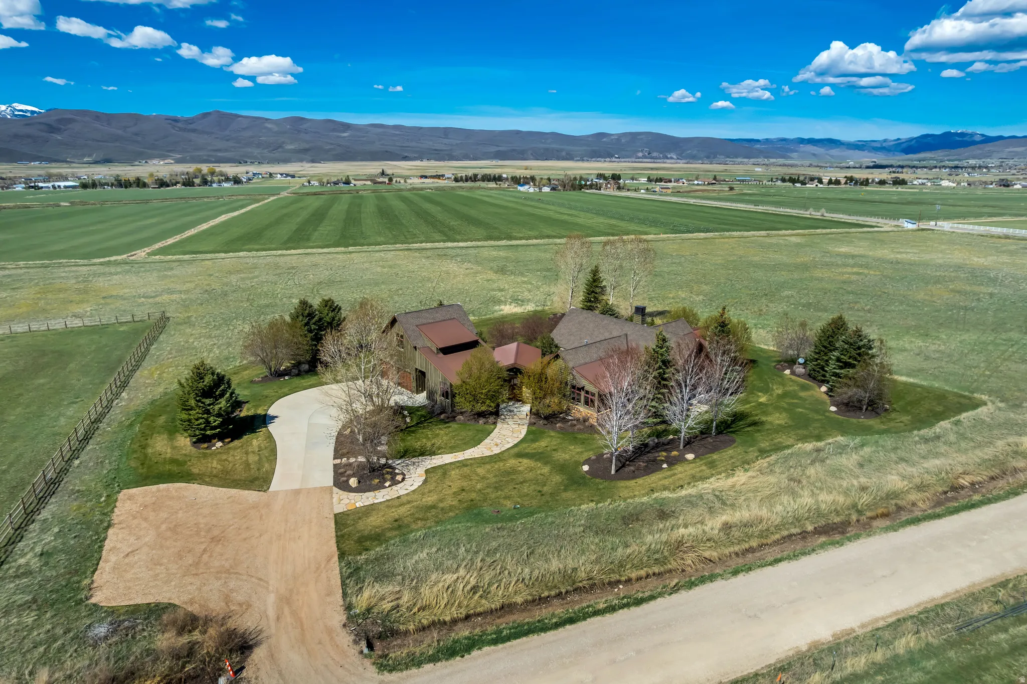 Aerial view of sparsely populated area featuring agricultural land and a mountainous background