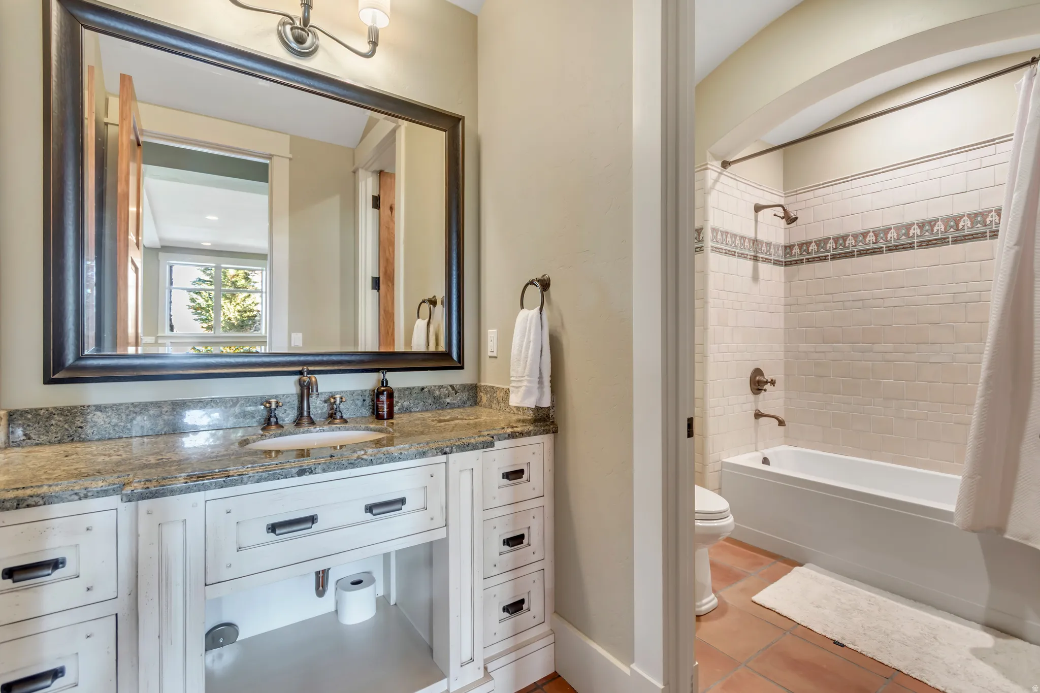 Full bathroom featuring vanity, shower / bath combo with shower curtain, and light tile patterned flooring