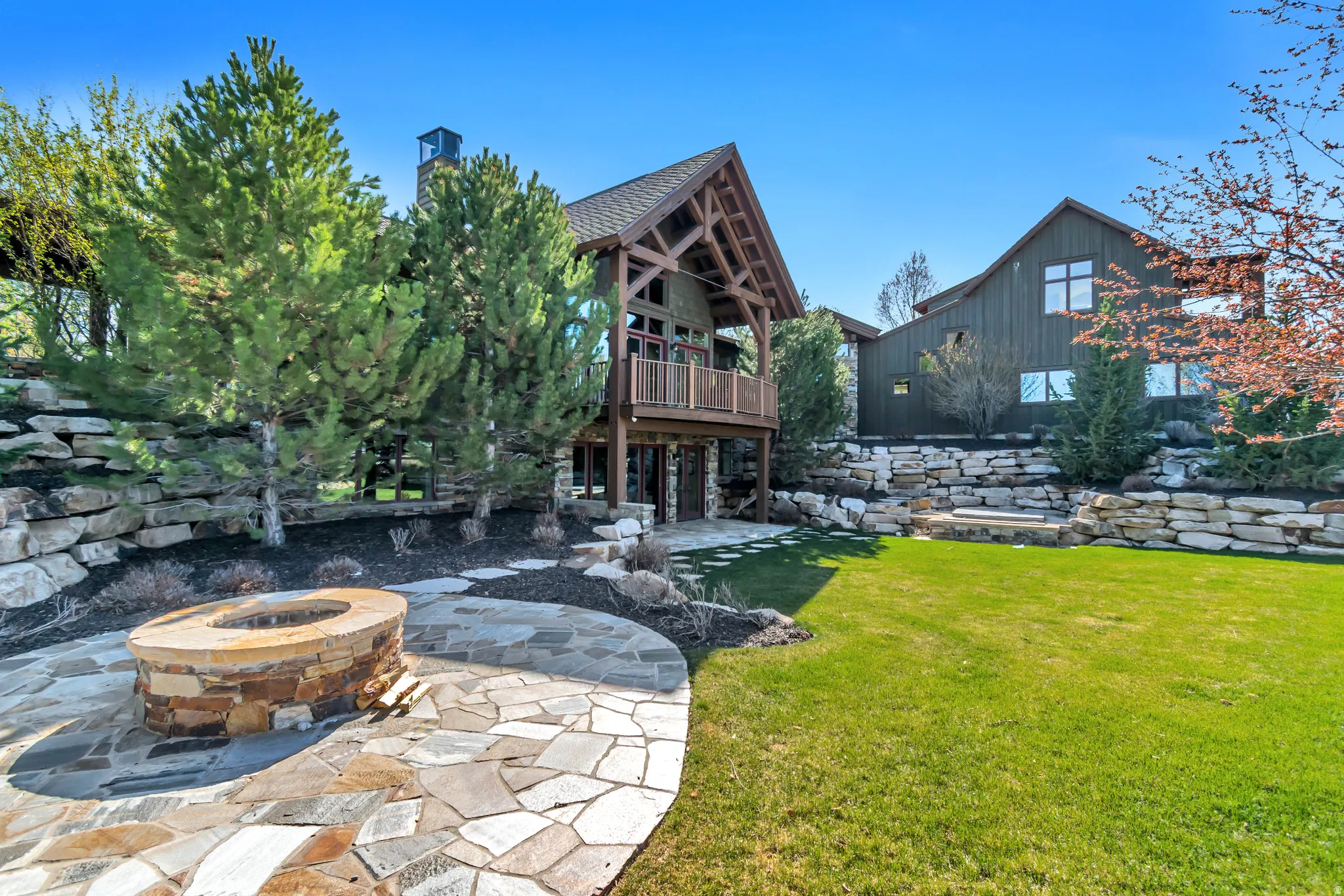 View of grassy yard featuring a fire pit and a patio area