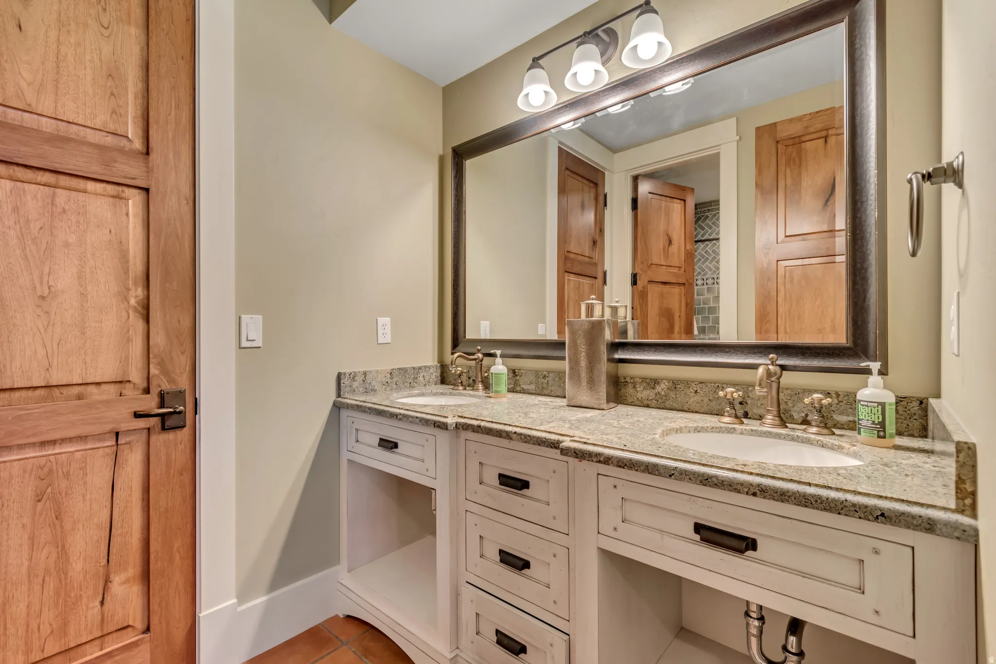 Full bathroom with double vanity and baseboards