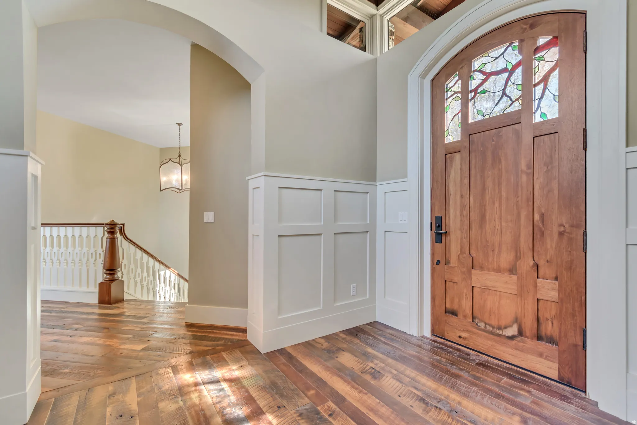 Entryway with wood-type flooring and suspended lighting