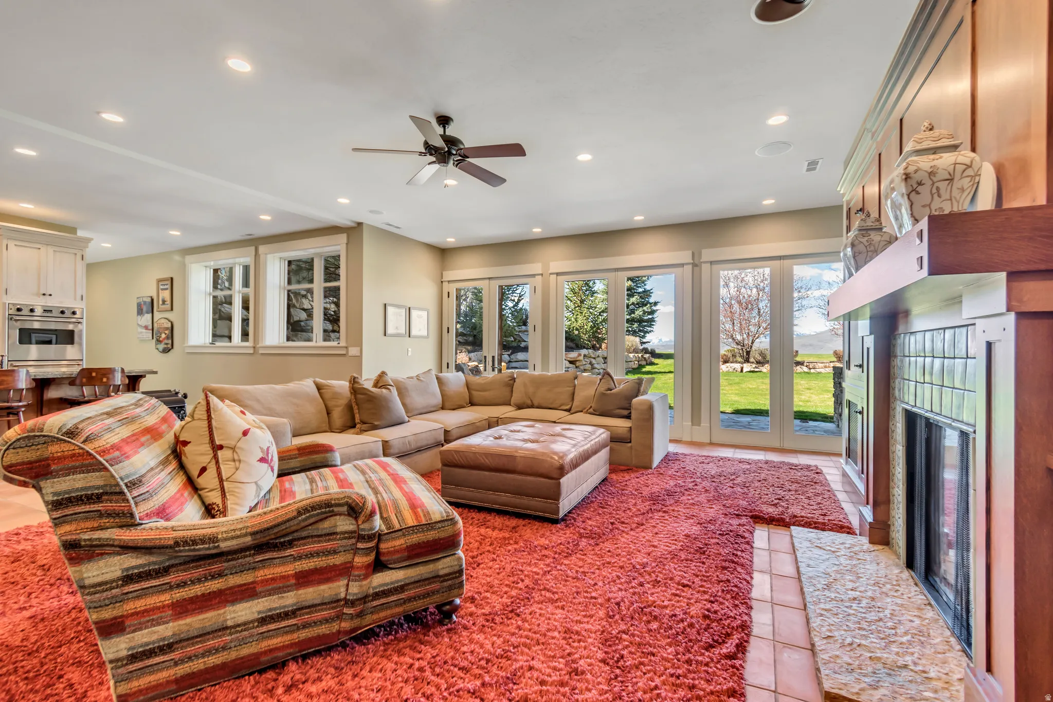 Living area with recessed lighting, light tile patterned flooring, ceiling fan, and a fireplace