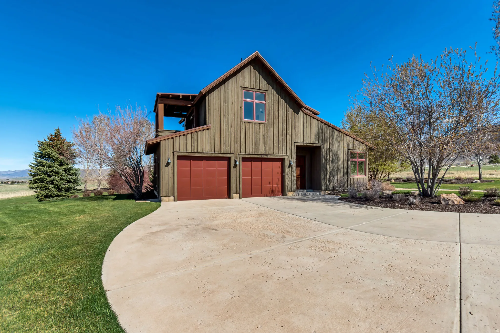 View of front of home with concrete driveway, a front yard, board and batten siding, and a garage